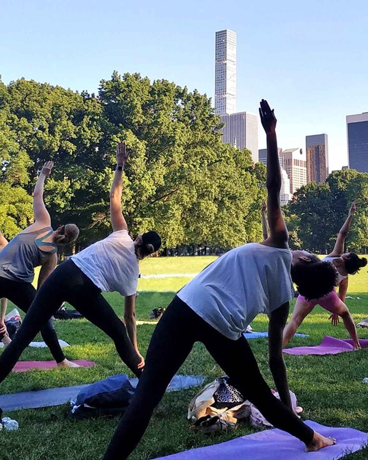 Students in Triangle pose at a Central Park yoga class